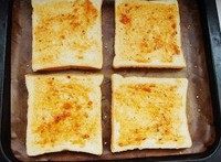 2、土司披萨,将吐司片上均匀涂上一层批萨酱或番茄酱