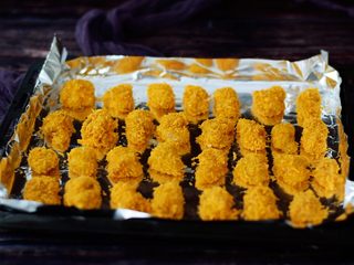 8、烤箱版鸡米花,烤盘铺上锡纸,把做好的鸡肉块依次放入烤盘中