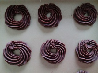 7、冬天也好挤的巧克力曲奇,挤曲奇的时候，烤箱开启180度预热。右手拿着装有面糊的裱花袋的尾部，垂直的离烤盘2厘米左右，用力均匀的将面糊画圈挤出来，每块曲奇之间要留间隙，饼干在烘烤的过程会膨胀，防止粘连!