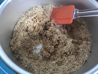 3、八寸芒果慕斯蛋糕,软化好的黄油和饼干搅拌均匀