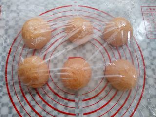 6、番茄咸肉面包, 取出面团轻轻排气，平均分成6份，滚圆，盖上保鲜膜静置10分钟