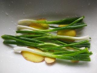 9、千张鲈鱼,葱姜洗净，葱留两根劈葱丝备用。其他的葱对半切段和姜，分两部分切葱片和葱丝，葱段和姜片摆放深盘中。