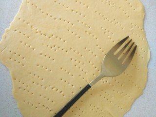 7、小龙虾新吃法~免烤箱薄饼披萨,然后取一个面剂子，擀成薄饼，像图中那样插上小孔