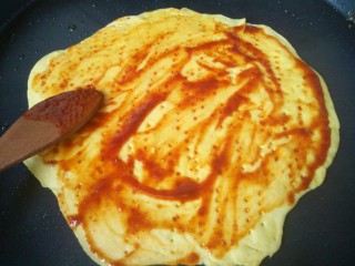 9、小龙虾新吃法~免烤箱薄饼披萨,用一个调羹给涂抹均匀，底部开火