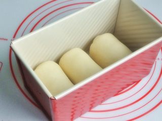 8、香肠吐司披萨,再次擀开成长条状，面团卷起，收口朝下放置，将面团放入吐司模。