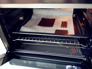 18、可可钢琴蛋糕,将可可面团在两张油纸间擀成均匀的厚片,另切几个稍粗的细条做钢琴支架,放入烤箱中层,上下火155度烤10分钟左右