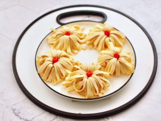 10、凉拌菊花豆皮,做好的菊花豆皮码放在盘中,做几个胡萝卜小花芯,放在豆皮中间。