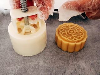 17、木糖醇栗子蓉月饼,然后把模具倒扣到已准备好的烤盘上,用力均匀地往下压紧。