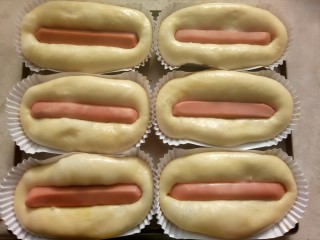 13、热狗面包,把香肠放在面包中间,用手指按到底。挤上番茄酱和沙拉酱。