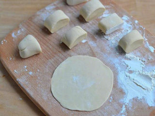 5、黄金肉饼,将醒发好的面团分成大小均匀的8份,然后擀成中间厚边缘薄的薄面皮;