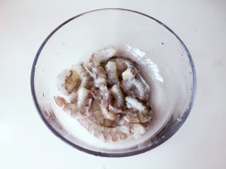 1、培根卷大虾披萨,将鲜虾洗干净，去头去尾去虾线