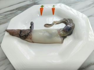 2、#做妈妈的拿手菜#爆炒鱿鱼,把解冻的鱿鱼洗干净，去除内脏，尾部，眼睛，还有鱿鱼皮，再次用清水冲洗干净。（如果你不愿意去皮也可以。）