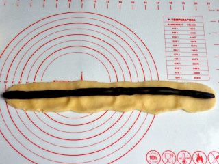 9、豆沙一口酥,将面团压成片状，将豆沙条放中间。