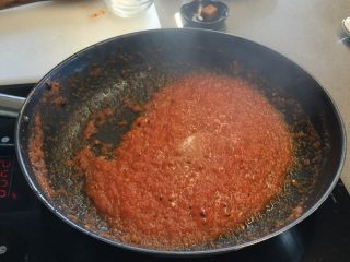 2、冬阴功鸡腿培根披萨,加入盐、糖、冬阴功酱和柠檬汁调味，收汁至无明显水分的状态，此时番茄酱应为原来的1/2