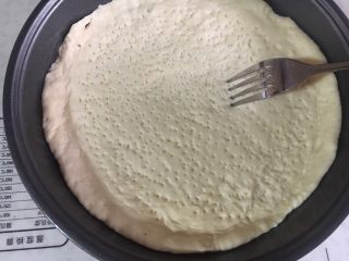 13、意式鲜虾烟熏香肠披萨,铺入披萨盘中，四周推厚，形成自然的卷边。并用叉子叉出均匀的孔。