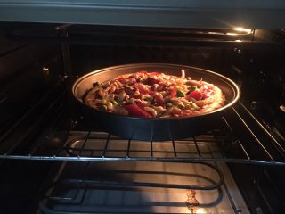 19、意式鲜虾烟熏香肠披萨,放入烤箱中层，上下火200度，烤15分钟。