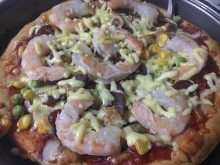 20、意式鲜虾烟熏香肠披萨,取出摆入鲜虾，在放一些马苏里拉芝士。放入烤箱烤5分钟，芝士融化即可。因为虾是焯过水的，熟的，所以最后烤一下就可以。