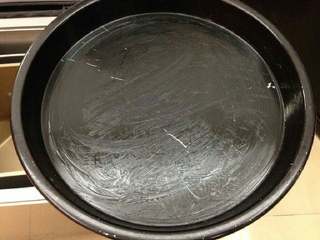 1、培根洋葱披萨,烤盘中涂一层黄油。