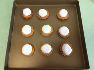 12、棉花糖淋酱夹心曲奇饼干,取一半饼干底部向上放在烤盘上，每一块饼干上放一块棉花糖，放入烤箱180度烤5分钟左右。