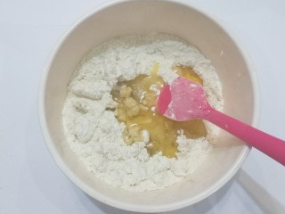 3、花生小酥饼,将花生油和全蛋液倒入面粉中拌均匀;
