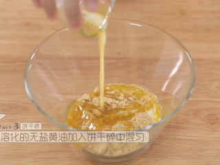 3、蓝莓益力多慕斯,把熔化成液体的无盐黄油加入饼干碎里面用打蛋器混匀，没有的朋友用刮刀也可以的