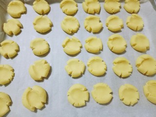 12、玛格丽特饼干,揉圆球后用大母手指按压，按扁的时候，饼干会出现自然的裂纹。依次做完。(一定要用大拇指将小圆球按扁，有裂痕是正常的，要的就是这效果。)