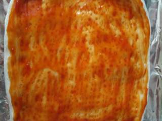 3、培根虾仁披萨,放烤箱150度烤10分钟，拿出来刷披萨酱，或者番茄酱，随个人口味