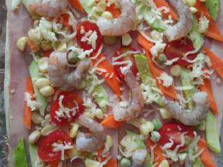 5、培根虾仁披萨,放上准备好的蔬菜和虾仁，洒上芝士碎放烤箱200度烤10-15分钟，根据披萨大小