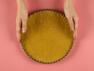 2、糖果饼干披萨,圆形模具垫烘焙纸，放入面糊铺平，放入冰箱冷冻30分钟，再放入预热好180℃的烤箱烤约15分钟，取出晾凉