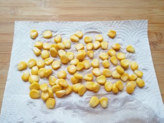 1、手抓饼披萨,玉米粒焯熟晾凉，用厨房用纸吸去多余的水分。