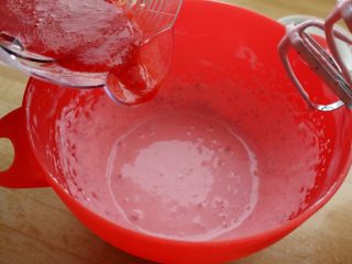 4、草莓冻芝士,6.然后分多次加入草莓汁，每加一次都用打蛋器低档打顺滑。