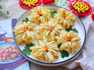 18、凉拌豆皮版花开富贵,浇入盘中或蘸着吃，一盘寓意花开富贵的凉拌菊花豆皮就做好了。