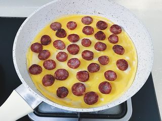 16、腊肠煎饼果子,将煎好的腊肠摆在上面