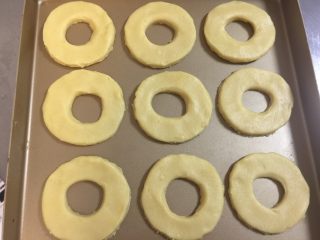 9、甜甜圈饼干,将压好的甜甜圈面胚放入烤盘。