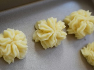 14、小花曲奇,然后装入裱花袋挤入烤盘中。最好用硅胶的裱花袋，不容易破