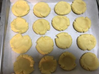 8、酥掉渣的桃酥,中间压扁，放到油纸上，烤箱180度预热10分钟。