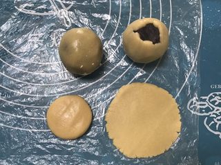 7、广式红豆沙月饼,取一个面团用手掌摁一下擀成圆形，包上豆沙用虎口慢慢收紧，