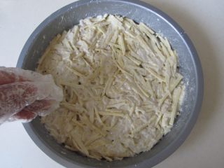 6、火腿杂蔬红薯披萨,将准备好的红薯丝面糊平铺在披萨盘的底部；