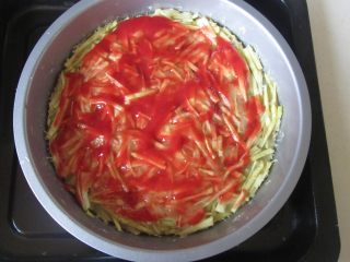 8、火腿杂蔬红薯披萨,这样红薯披萨饼底就烤好了， 再在上面涂抹一层番茄酱，撒点牛至叶；