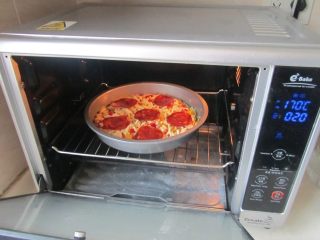 11、火腿杂蔬红薯披萨,再放入预热170度烤箱中， 中下层， 再烤10分钟，拿出来后再表面上摆上香草叶即可。