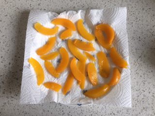 1、黄桃全麦披萨,先来处理黄桃罐头，把黄桃从罐头中取出，用厨房用纸吸干水分，把黄桃切片，放一边晾干水分备用