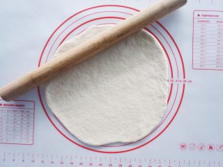 8、咖喱土豆泥披萨,将发酵好的面团擀成一个均匀的薄饼，尽量把气泡都赶出去，这样一会儿烤的时候才不会起鼓。