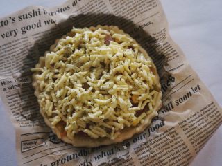 12、咖喱土豆泥披萨,铺上肉肠、小番茄、玉米粒、红萝卜丝、帕玛森芝士碎（喜欢多吃芝士的可以多放根据自己口味调整）再撒上适量迷迭香（没有迷迭香可以不加，迷迭香起增加风味作用）