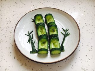 5、翠竹报春,将挖好槽的6节黄瓜节摆放在盘子里，用黄瓜皮剪成小竹叶，装饰一下。