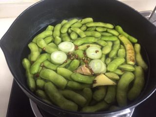 4、糟卤毛豆,锅里放水、葱、姜、花椒把毛豆煮熟，水开煮五分钟左右就熟了。