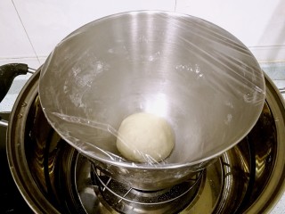 3、榴莲披萨,把面团揉圆，放入厨师机，盖上保鲜膜，置于温暖湿润的环境发酵。