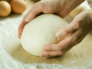 2、意大利玛格丽特披萨,将搅好的面团取出操作台，使用湿毛巾盖好醒面10分钟。再用面团割刀切200g／一个，用手搓圆。