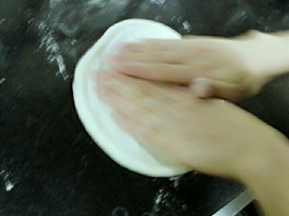 4、意大利玛格丽特披萨,使用一个发酵好的面团，撤上适量的面粉用手撑心压面团中心位置，搓扁搓开搓平搓圆为止，面粉不要过多，免得搓不开，不粘水就行。