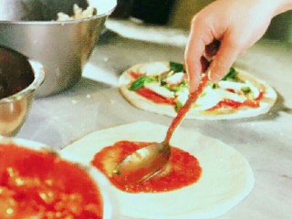 5、意大利玛格丽特披萨,摊好的饼底之后使用制作好的番茄酱涂抹好在上面，记得留边。