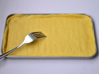 8、金枪鱼披萨,放入烤盘中，用叉子叉一些小孔，静置一会排气